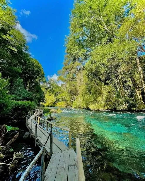 Camino de madera junto a un río de aguas turquesa, en el Mirador de Peces
